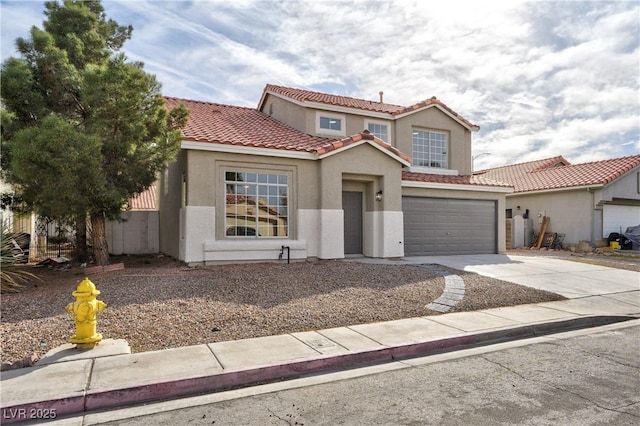 mediterranean / spanish home with concrete driveway, an attached garage, a tile roof, and stucco siding