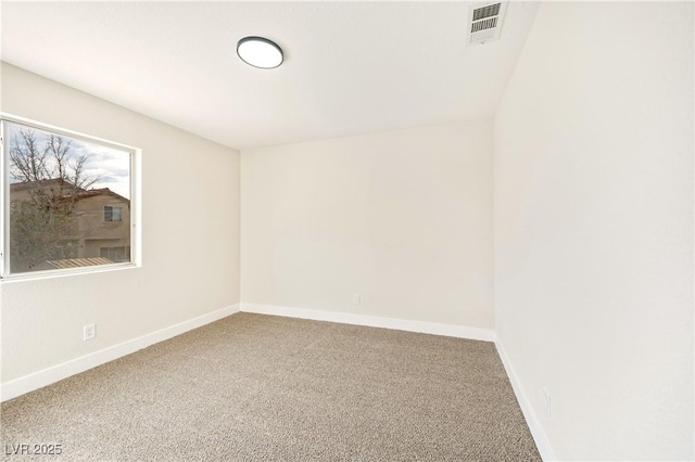 carpeted spare room featuring visible vents and baseboards