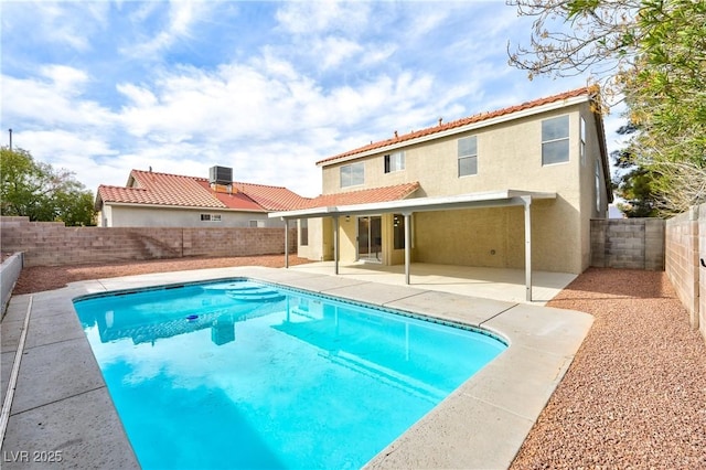 rear view of property with a fenced in pool, a patio, stucco siding, a fenced backyard, and a tiled roof