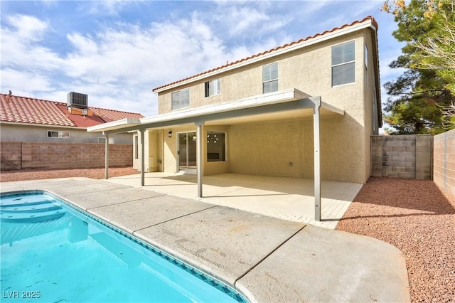 rear view of property featuring a patio, a fenced backyard, central AC, a tile roof, and stucco siding