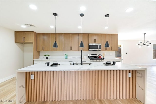 kitchen with visible vents, an island with sink, stainless steel appliances, a sink, and recessed lighting