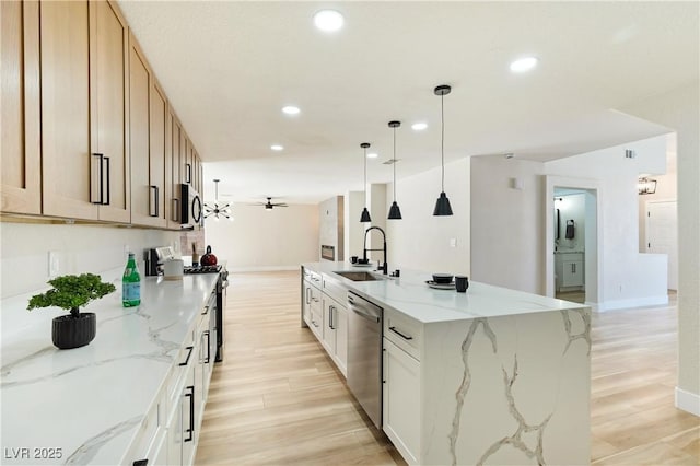 kitchen featuring stainless steel appliances, recessed lighting, light wood-style flooring, a ceiling fan, and a sink