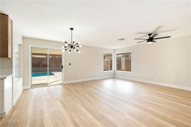 unfurnished living room featuring baseboards, visible vents, plenty of natural light, and light wood finished floors