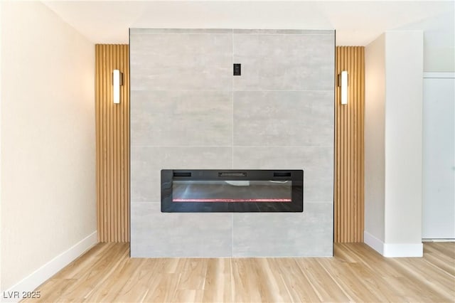 interior details with baseboards, wood finished floors, and a tile fireplace