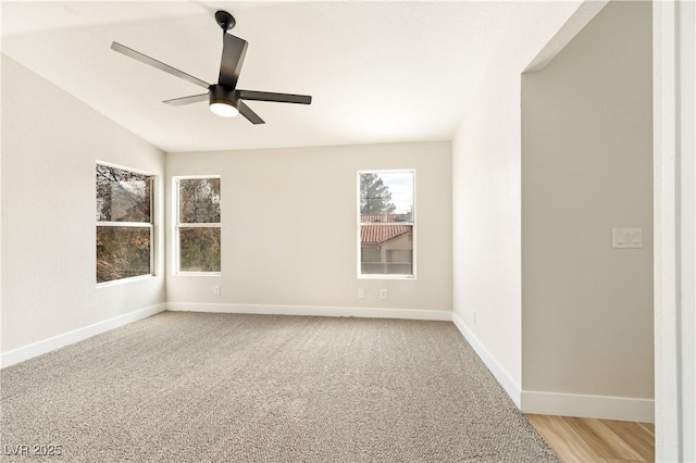 unfurnished room with light carpet, lofted ceiling, a ceiling fan, and baseboards