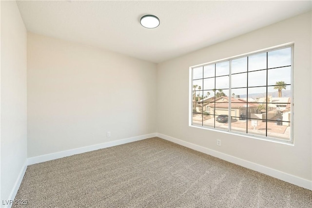 carpeted spare room with baseboards