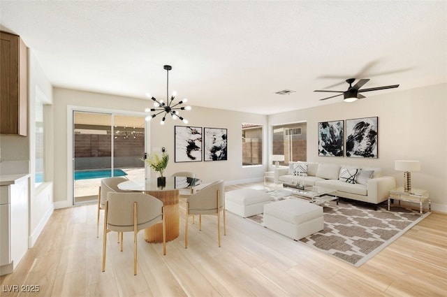 living room featuring a wealth of natural light, light wood-style flooring, visible vents, and baseboards