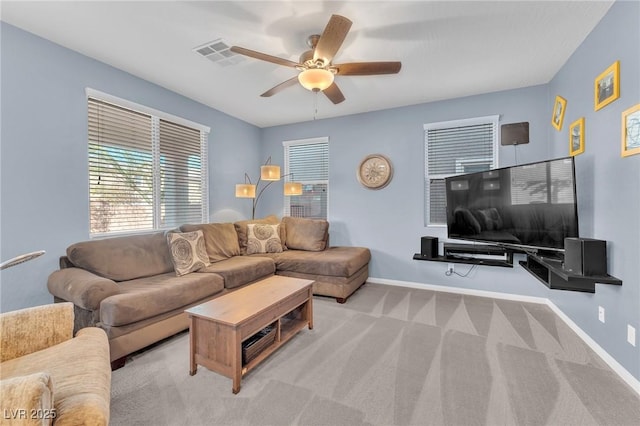 living room with a ceiling fan, carpet flooring, visible vents, and baseboards