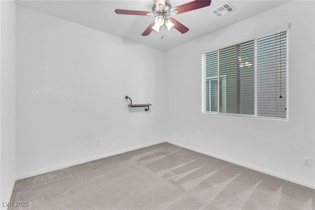 empty room with carpet floors, baseboards, visible vents, and ceiling fan