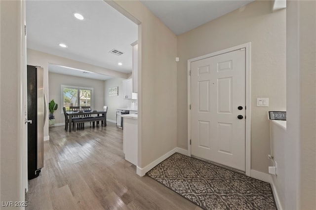 foyer featuring baseboards, recessed lighting, visible vents, and light wood-style floors