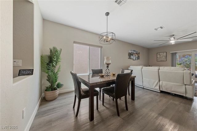 dining space with a ceiling fan, baseboards, visible vents, and wood finished floors