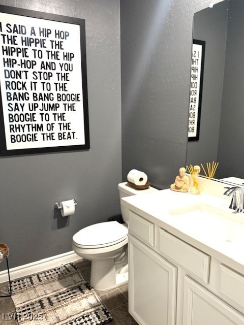 bathroom with tile patterned flooring, toilet, vanity, and baseboards