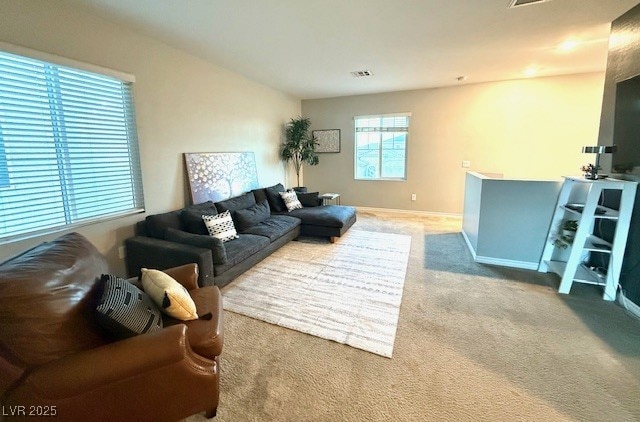 living room with carpet, visible vents, and baseboards