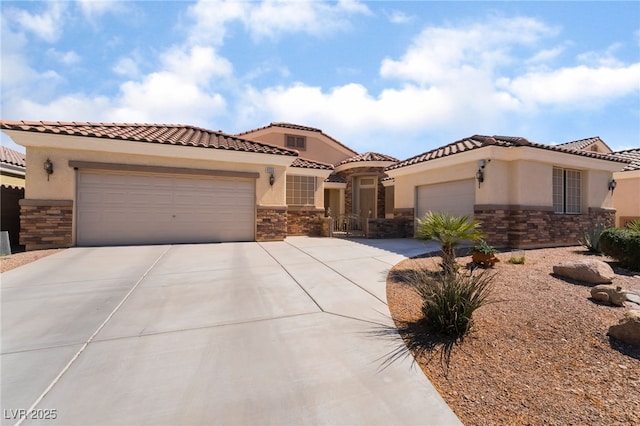 mediterranean / spanish home featuring stone siding, stucco siding, concrete driveway, and a garage