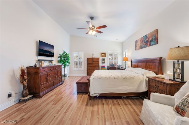 bedroom featuring vaulted ceiling, multiple windows, and light wood-style floors