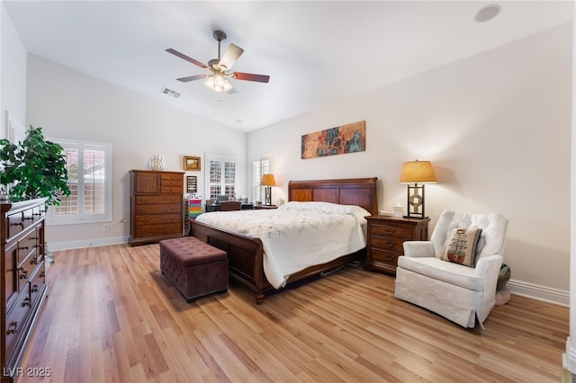 bedroom with lofted ceiling, multiple windows, visible vents, and light wood finished floors