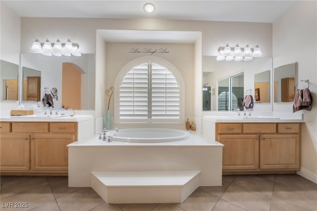 bathroom with tile patterned floors, two vanities, a bath, and a sink