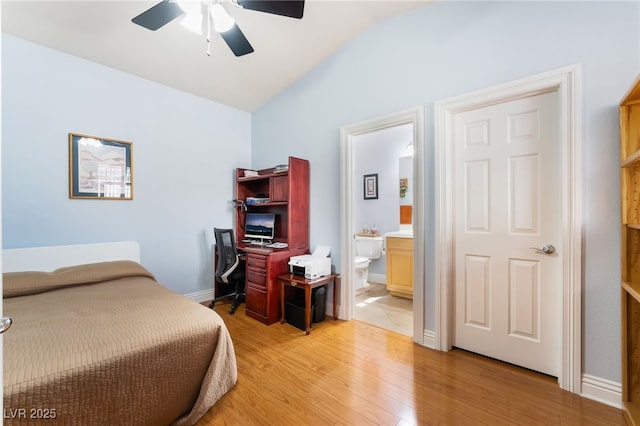 bedroom with a ceiling fan, baseboards, lofted ceiling, ensuite bathroom, and light wood-type flooring