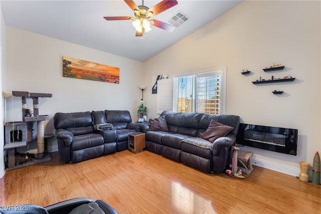 living area with light wood finished floors, visible vents, ceiling fan, baseboards, and lofted ceiling