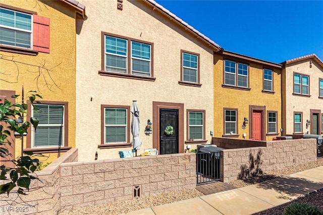 view of property with a fenced front yard, stucco siding, and a tiled roof