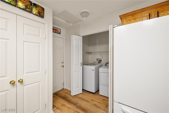 laundry room featuring laundry area, attic access, separate washer and dryer, and light wood-style floors