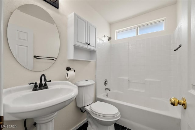 bathroom featuring toilet, shower / washtub combination, and a sink