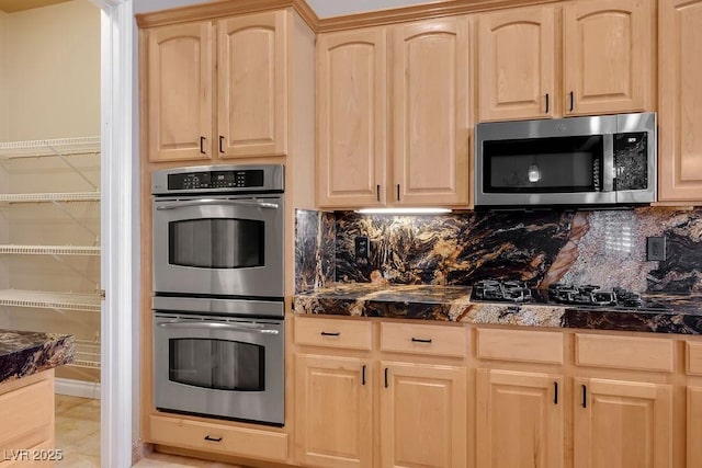 kitchen featuring stainless steel appliances, tasteful backsplash, and light brown cabinets