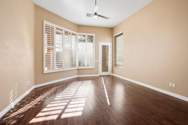 spare room featuring baseboards, wood finished floors, and a ceiling fan