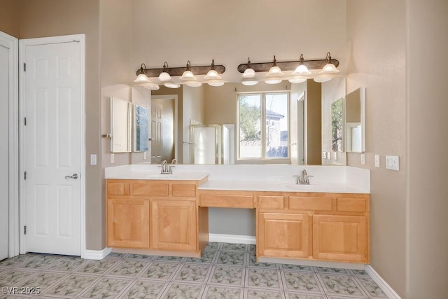 bathroom featuring a sink, baseboards, a shower stall, and double vanity