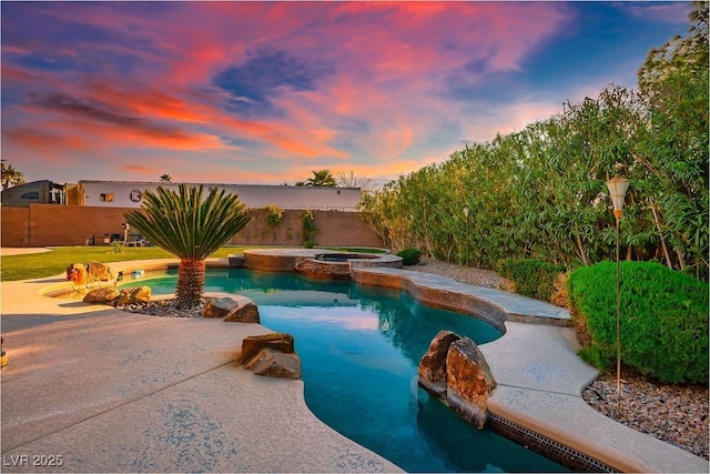 view of pool featuring a fenced backyard and a pool with connected hot tub