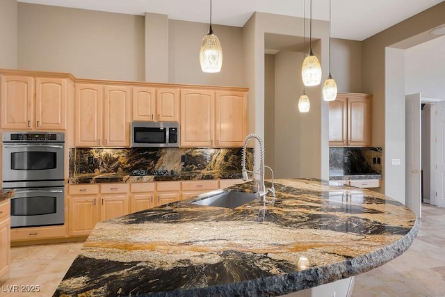 kitchen with light brown cabinetry, stainless steel appliances, a high ceiling, and a sink