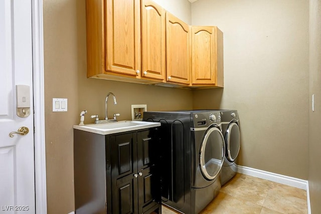 washroom with washer and dryer, cabinet space, baseboards, and a sink