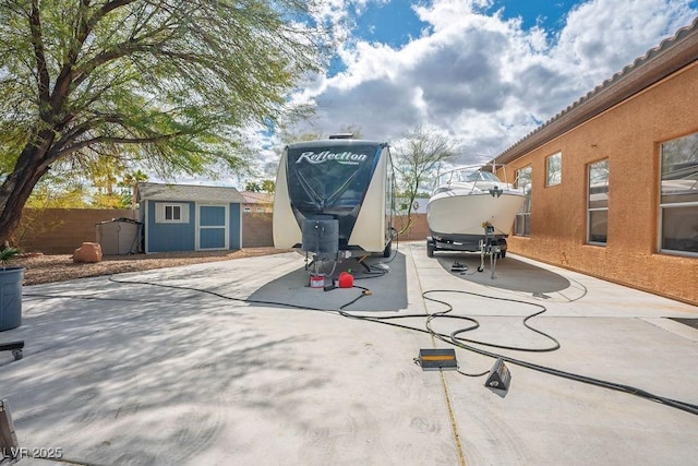 view of patio / terrace with a storage shed, an outdoor structure, and fence