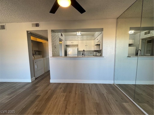 kitchen featuring fridge, visible vents, separate washer and dryer, and dark wood-style flooring