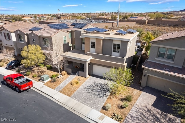 view of front of property featuring a garage, decorative driveway, a residential view, and stucco siding