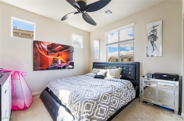 carpeted bedroom featuring visible vents, ceiling fan, baseboards, and multiple windows