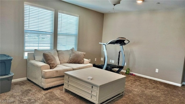 living room featuring baseboards and dark carpet