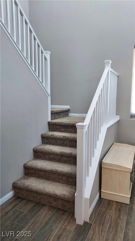 staircase with wood finished floors and baseboards