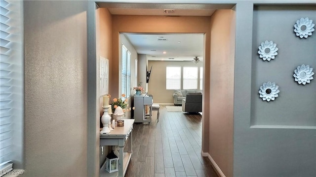 hallway with dark wood finished floors and baseboards