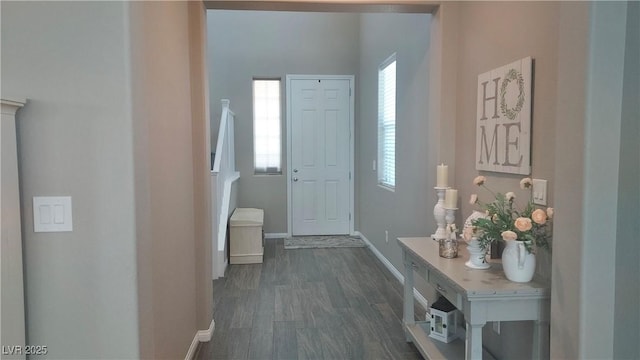 interior space with plenty of natural light, baseboards, and dark wood finished floors