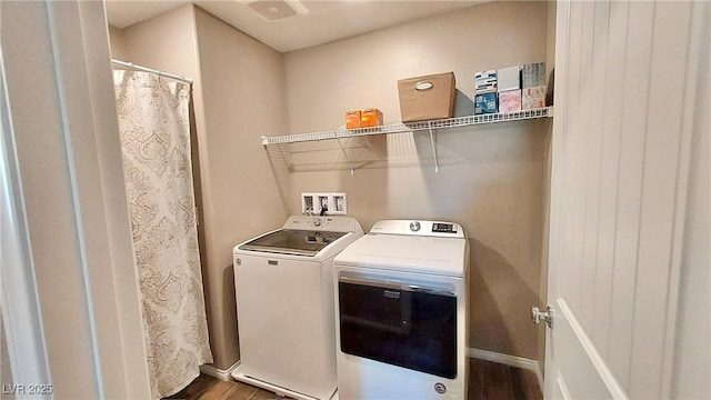 washroom featuring laundry area, baseboards, washing machine and clothes dryer, and wood finished floors