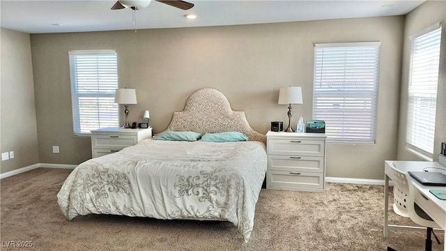 bedroom with light colored carpet, ceiling fan, baseboards, and multiple windows