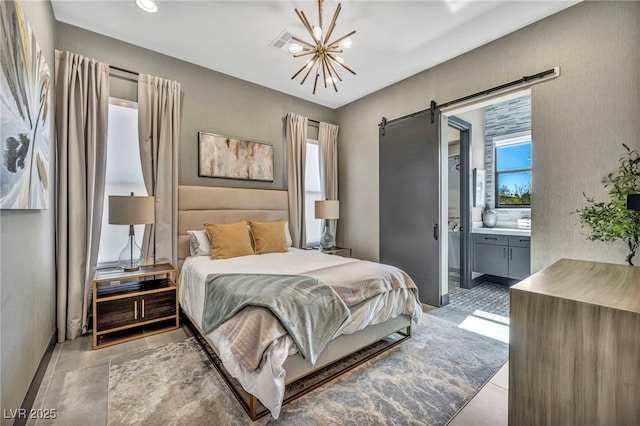 bedroom with a chandelier, a barn door, and ensuite bathroom