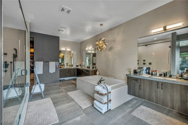 full bathroom featuring two vanities, visible vents, a sink, a bath, and a stall shower