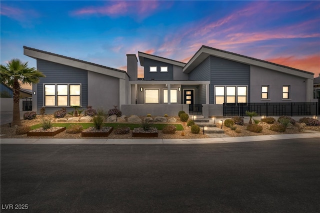 modern home featuring fence and stucco siding