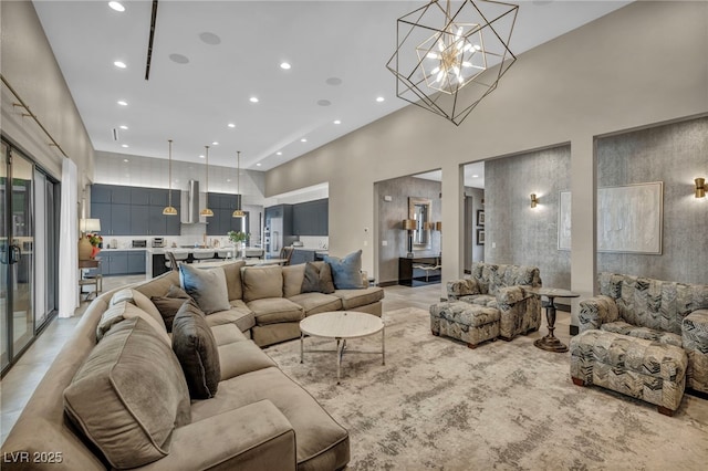 living room with an inviting chandelier, a high ceiling, and recessed lighting