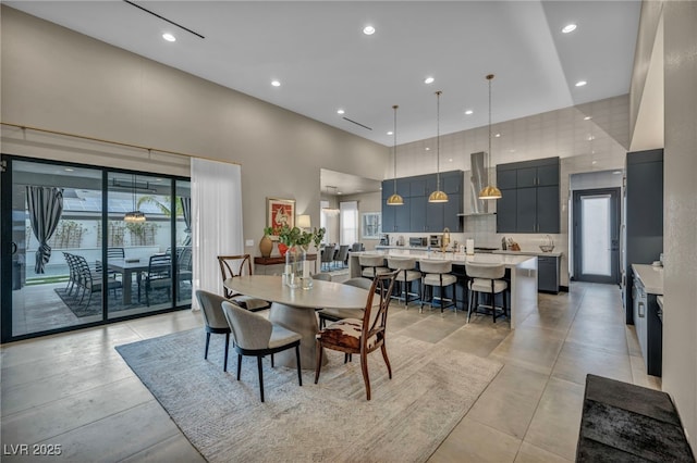 dining room featuring a high ceiling and recessed lighting