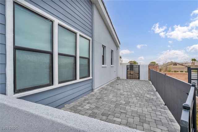 view of side of home featuring a patio area and fence