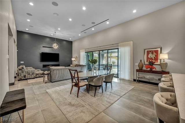 dining room featuring an accent wall, recessed lighting, and a high ceiling