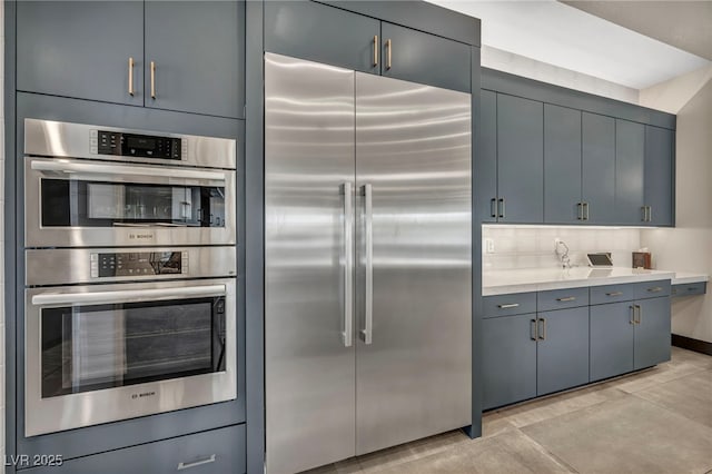 kitchen featuring tasteful backsplash, appliances with stainless steel finishes, and light countertops